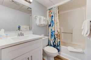 a white bathroom with a sink and a toilet at 0705 Palms That Sway by Atlantic Towers in Carolina Beach