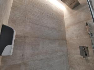 Apartamento de Lujo - A 10 minutos del centro في مدريد: حمام مع دش مع جدار من البلاط