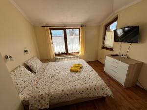 a bedroom with a bed with two yellow towels on it at VV Apartment Bansko in Bansko