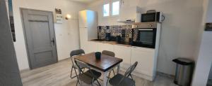 a kitchen with a table and chairs in a room at LE PECHE MIGNON - Appart 1 - locationlatamarissiere in Agde