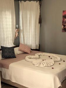 ダルヤンにあるHan Dalyan Hotelの毛布2枚と花が飾られたベッド
