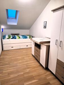 ein kleines Schlafzimmer mit einem Bett und einem Holzboden in der Unterkunft Moderne, Ferienwohnung mit Seeblick, near Hallstatt in Bad Goisern