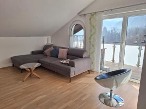 ein Wohnzimmer mit einem Sofa und einem großen Fenster in der Unterkunft Moderne, Ferienwohnung mit Seeblick, near Hallstatt in Bad Goisern