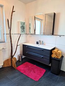 ein Bad mit einem Waschbecken und einem Spiegel in der Unterkunft Moderne, Ferienwohnung mit Seeblick, near Hallstatt in Bad Goisern