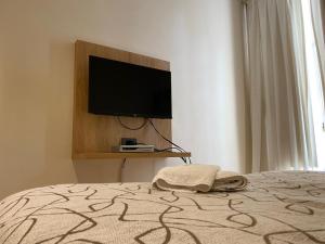 um quarto com uma cama e uma televisão na parede em Centro Plaza Hotel em Concordia
