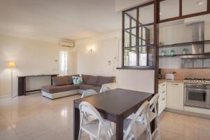 een keuken en een woonkamer met een tafel en een bank bij Villa Ilaria with private pool and lake view in Torri del Benaco