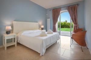 een slaapkamer met een wit bed en een groot raam bij Villa Ilaria with private pool and lake view in Torri del Benaco