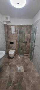 a bathroom with a shower and a toilet and a sink at Apartament Morskie Oko in Międzyzdroje