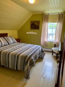 a bedroom with a bed and a large window at À la croisée des sommets in Notre-Dame-Des-Bois