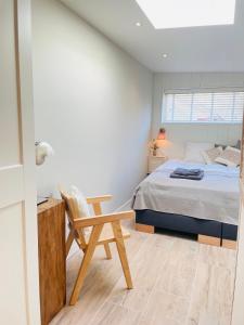 1 dormitorio con cama, escritorio y silla en Villa de Duinfazant, en Bergen aan Zee