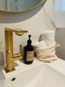 a bottle of soap sitting on a sink next to a faucet at Villa de Duinfazant in Bergen aan Zee