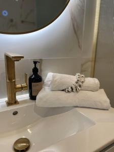 a bathroom sink with towels and a mirror at Villa de Duinfazant in Bergen aan Zee