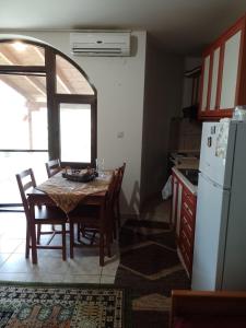 a kitchen with a table and a white refrigerator at Rooms Kakudia in Ierissos