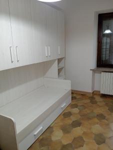 a white kitchen with a bench in a room at Anticopodere in Casorzo