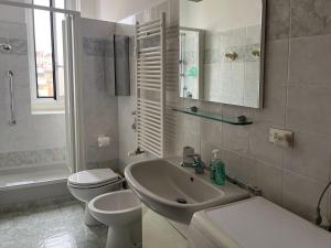 uma casa de banho branca com um lavatório e um WC em Clodì em Milão