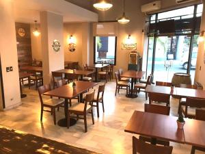 a restaurant with wooden tables and chairs and windows at Centro Plaza Hotel in Concordia