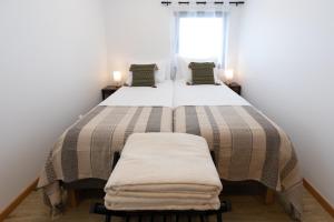 a bedroom with a large bed with two pillows at Casinha da Praia - Beachside Retreat Almoxarife in Praia do Almoxarife