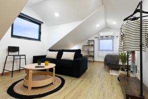 a living room with a black couch and a table at Casinha da Praia - Beachside Retreat Almoxarife in Praia do Almoxarife