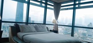 een bed in een kamer met grote ramen bij Urban Suite Times Square Kuala Lumpur in Kuala Lumpur
