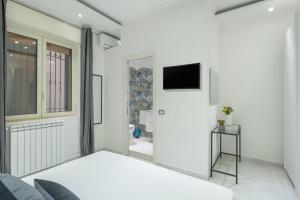 1 dormitorio con 1 cama y TV en la pared en Pangea Luxury Rooms Oplonti, en Torre Annunziata