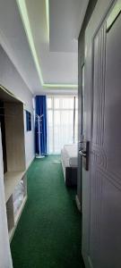 a room with a bed and a green carpet at Jerusalem Hotel in Gitega