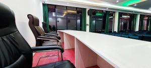 a conference room with chairs and a white counter and windows at Jerusalem Hotel in Gitega