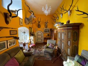 ein Wohnzimmer mit gelben Wänden und Geweihen an der Wand in der Unterkunft Gästehaus auf der Salzburg in Bad Neustadt an der Saale