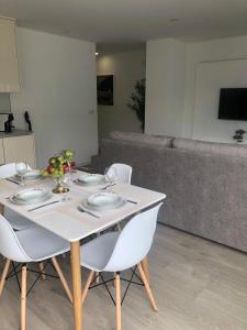 a white table with chairs and a couch at Apartamento Estrela do Mar in Nazaré