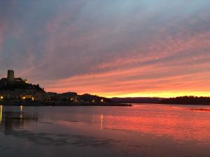 un tramonto su un corpo d'acqua con un castello di Appartement spacieux de plein pied avec 2 chambres, cuisine, salon, terrasse à 2 minutes de la plage a Gruissan Altre 6 foto