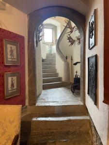 einen Flur mit Treppen und Gemälden an den Wänden in der Unterkunft Gästehaus auf der Salzburg in Bad Neustadt an der Saale + 11 Fotos
