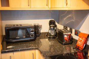 una encimera de cocina con tostadora y microondas. en 4 Wheelhouse Apartment, en Lochinver