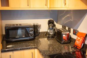 a kitchen counter with a toaster and a microwave on it at 4 Wheelhouse Apartment in Lochinver