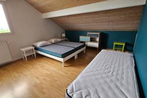 - une chambre avec 2 lits et un mur bleu dans l'établissement Chez Christine et Eric, à Lucinges