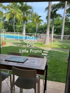 a wooden table and chairs in a yard with a pool at Little Prana in Saint-Gilles les Bains