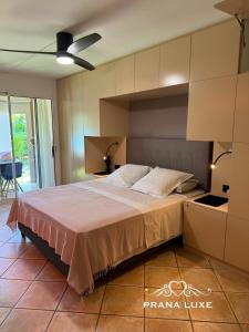 una camera con un grande letto e un ventilatore a soffitto di Little Prana a Saint-Gilles-les Bains