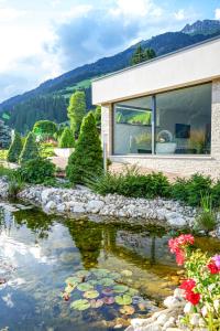 ein Haus mit einem Teich davor in der Unterkunft Residence Garni Melcherhof in Ratschings