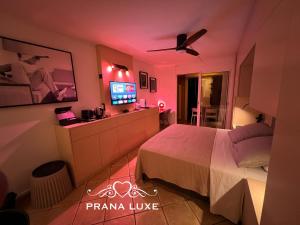 sypialnia z łóżkiem i telewizorem z płaskim ekranem w obiekcie Little Prana w mieście Saint-Gilles les Bains
