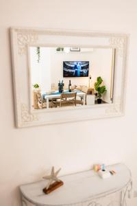 un miroir reflétant un salon avec une table dans l'établissement Casa Anita, à Terracine