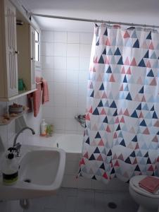 baño con lavabo y cortina de ducha en Margaritas Cottage, en Nauplia