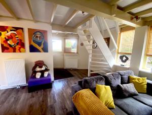 a living room with a couch and a staircase at Happy Little Maya Bee in Nieuwe-Niedorp