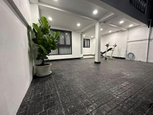 een grote kamer met een fitnessruimte met een potplant bij Private cozy house @Chatcuchak in Bang O