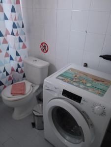 a bathroom with a washing machine and a toilet at Margaritas Cottage in Nafplio