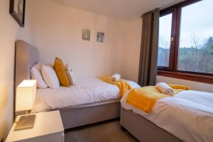 two beds in a room with a window at 4 Wheelhouse Apartment in Lochinver