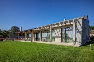 ein Gebäude mit Glastüren auf einem Grasfeld in der Unterkunft Eco complex Zdravets in Zdravets