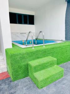 un escalón de césped frente a un edificio con piscina en Newly built Smart 4 bed rooms duplex in Ilasan ikate lekki en Lekki