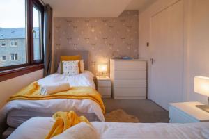 Un dormitorio con dos camas y una ventana. en 4 Wheelhouse Apartment, en Lochinver 2 fotos más