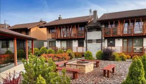 a courtyard with benches in front of a building at Apartmány Friends Tatry in Veľká Lomnica