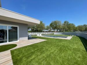 a backyard with green grass and a house at Polinesia 6 in Lido delle Nazioni