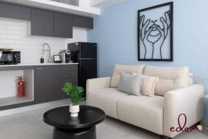 a living room with a couch and a kitchen at סוויטה מעוצבת עם מרפסת ליד הים - By Edomlux in Eilat