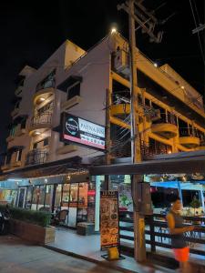 パタヤ・サウスにあるPauna Inn Pattayaの夜間の建物を通り過ぎる者